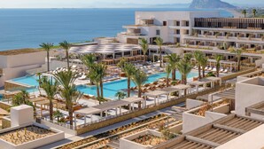A resort with a large pool area, multiple lounge areas, and a view of the sea and mountains. - Fairmont La Hacienda Costa del Sol (San Roque)