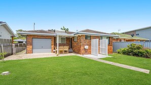 Une maison à deux étages avec un garage, un patio couvert et une pelouse bien entretenue.