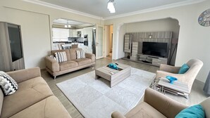 A modern living room with a sofa, coffee table, and TV stand.