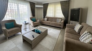 A living room with a sofa set, a coffee table, and a TV cabinet.