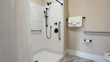 A modern bathroom with a walk-in shower, grab bars, a toilet, and a towel rack.