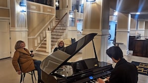 A grand piano in a spacious lobby with a staircase and a reception area in the background. - Historic Griffin Hotel (Griffin)