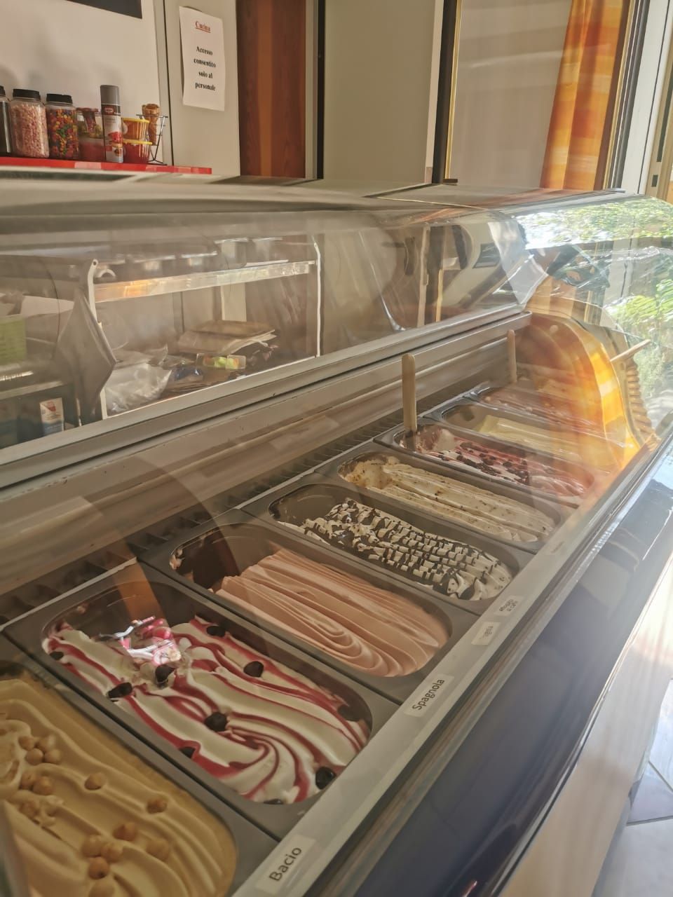 A dessert display case with various ice cream flavors.