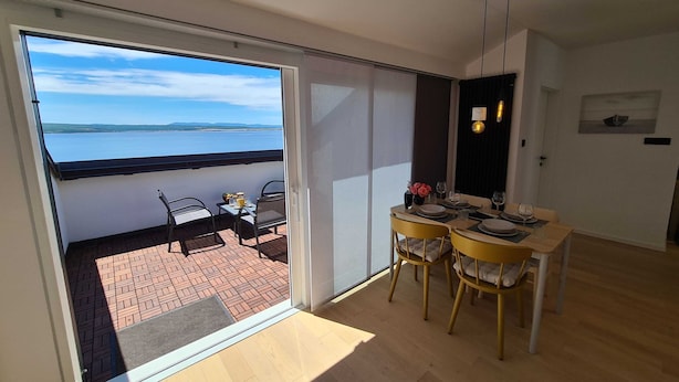 A modern interior with a balcony overlooking a body of water. - Stylish and Elegant Crikvenica Apartments (Crikvenica)