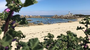 A beach with boats, a lighthouse, and rocky terrain. - Fully renovated farmhouse in village near a typical fishing port (Hôpital-Camfrout)