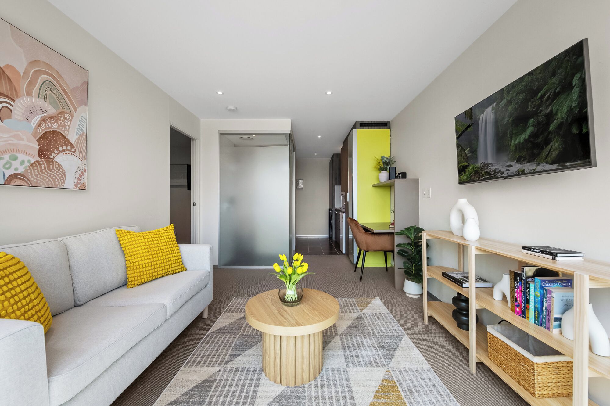A modern living room with a sofa, coffee table, and artwork on the walls.