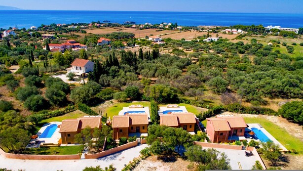 A coastal resort with multiple villas featuring swimming pools, surrounded by lush greenery and a view of the sea. - Rhea Villa in Kefallonia (Kefalonia)