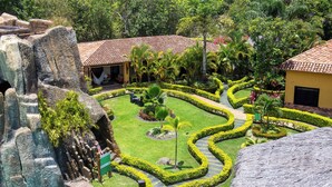 A tropical resort with a swimming pool, rock formations, and well-manicured gardens. - Posada Turistica Ara Meru Lodge (Gran Sabana)