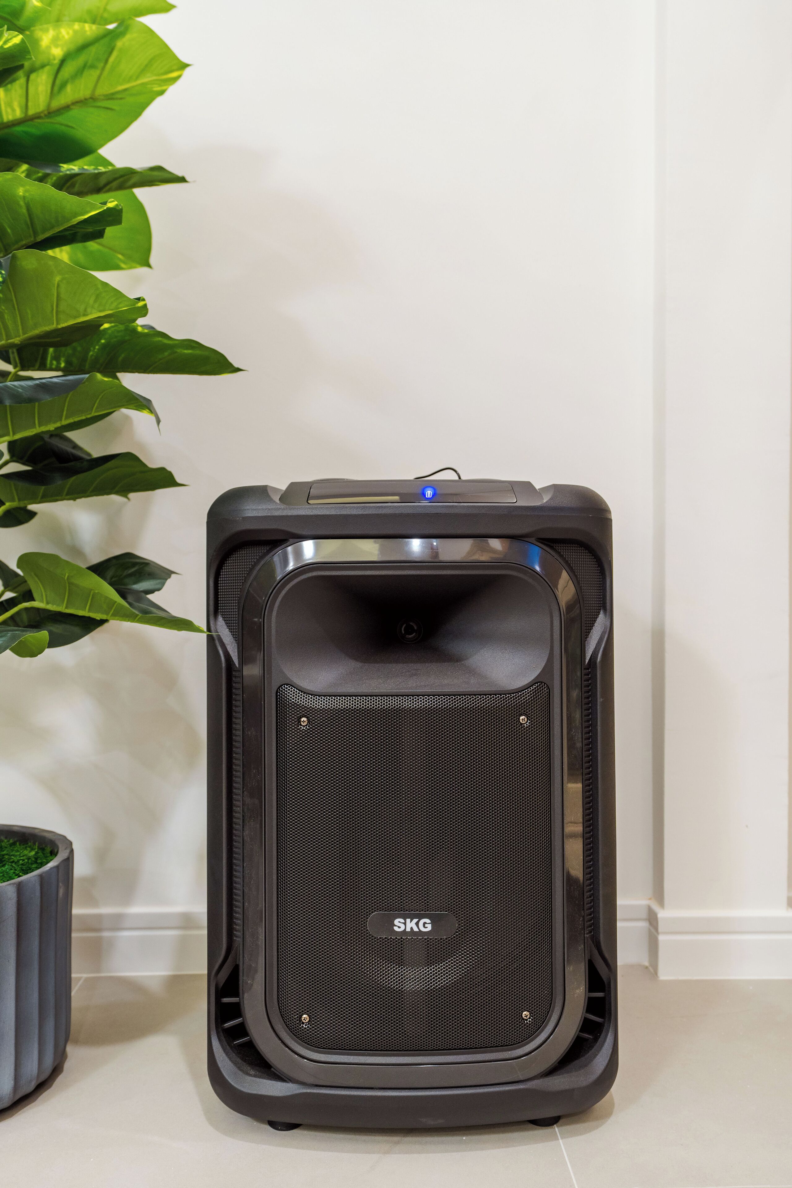 A portable speaker with a black exterior and a visible brand name 'SKG'.