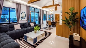 A modern living room with a sectional sofa, a coffee table, and a television.