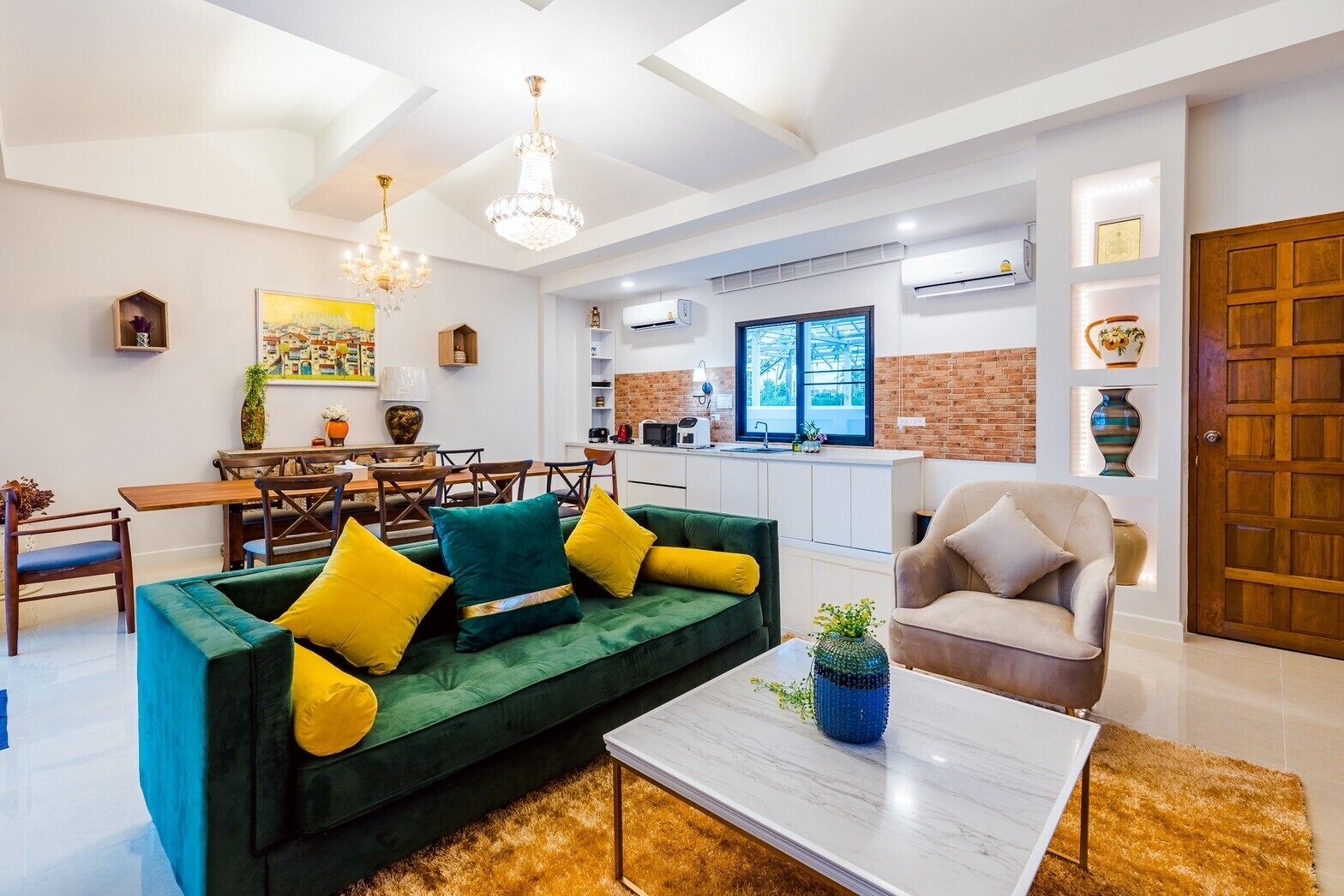 A modern living room with a green sofa, yellow cushions, a coffee table, and a dining area with wooden chairs and a table.