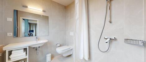 A modern bathroom with a sink, toilet, and shower.