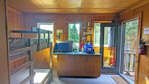 Une cuisine compacte équipée d’une cuisinière intégrée, d’un évier et d’une fenêtre donnant sur l’extérieur.