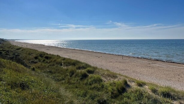 A beach with a clear sky and calm sea.