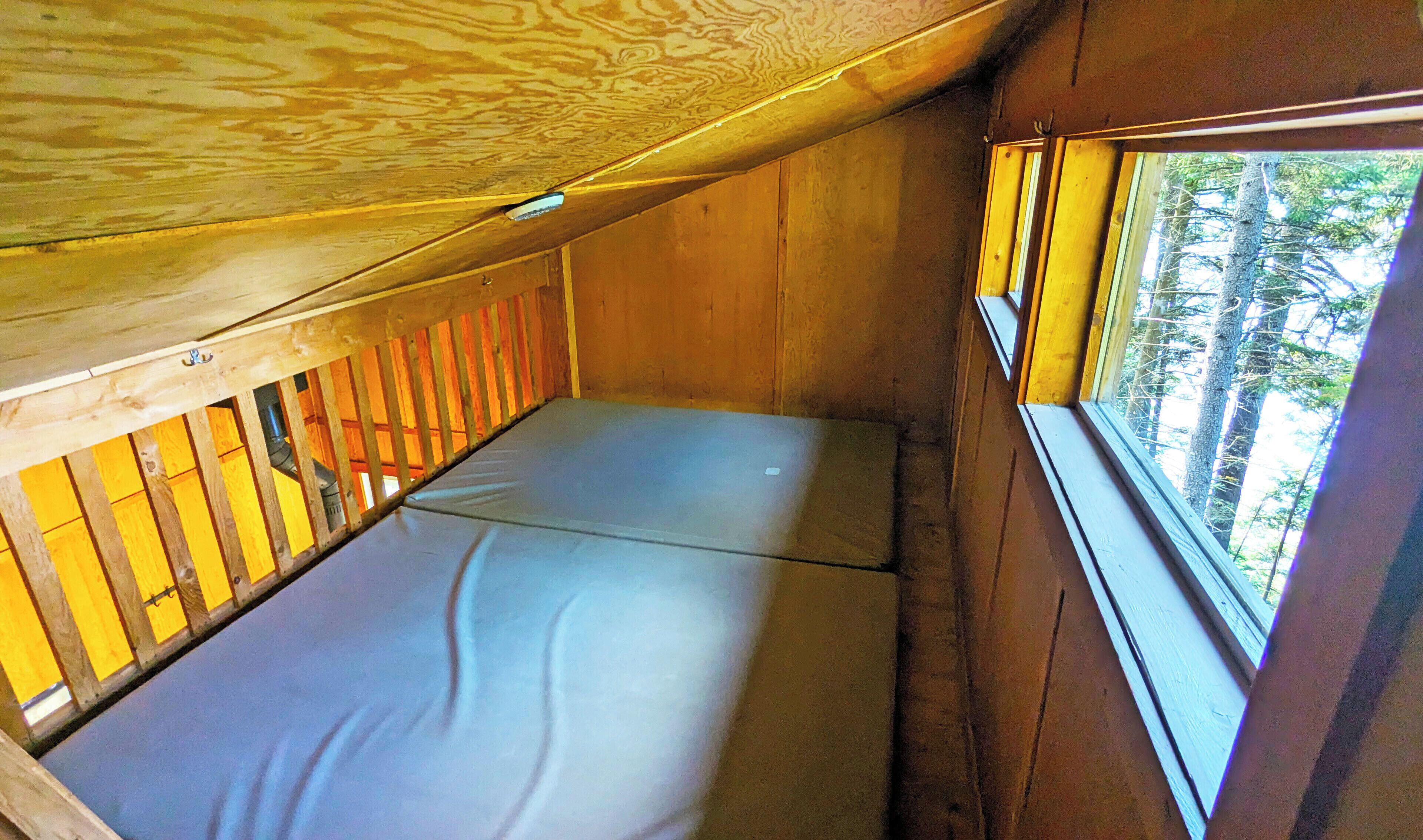 A small, enclosed sleeping area with a bunk bed and a window.