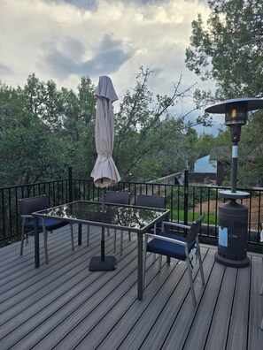 A deck with a glass-top table and chairs, surrounded by a black metal railing. - River access, Quiet, Family and pet friendly. Best mountain views in the valley (Payson)