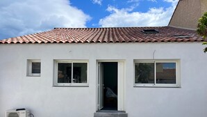 A building with a tiled roof, a white exterior, and a small entrance with steps. - LaVillaMaurice: A small, family-run fisherman's cottage—Summer 2026 Special (Valras plage)