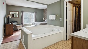 Une salle de bain avec une baignoire, un lavabo, un miroir et une fenêtre.