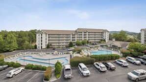 Un hôtel à plusieurs étages doté d’une piscine et d’un parking.