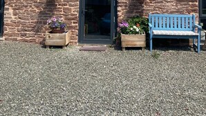 A stone building with a black door, two windows, and a blue bench in front. - Cosy 2 bed barn in Bannau Brycheiniog national park, with outdoor patio.  (Brecon, Powys)