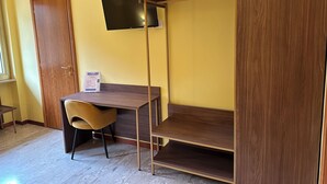 Une chambre avec un lit superposé, un bureau, une chaise et un téléviseur fixé au mur.