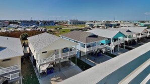 A coastal residential area with multiple two-story houses, some with balconies and attached garages. - Port A's Flip Flops & Pop Tops by Silver Sands Vacation Rentals (Port Aransas)