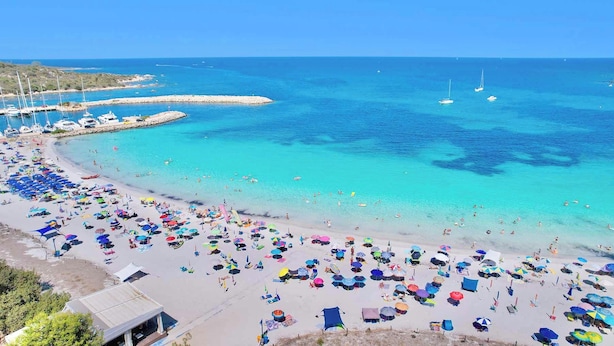 A beach with numerous colorful umbrellas and people enjoying the water. - Residence with swimming pool in Ottiolu (Budoni)