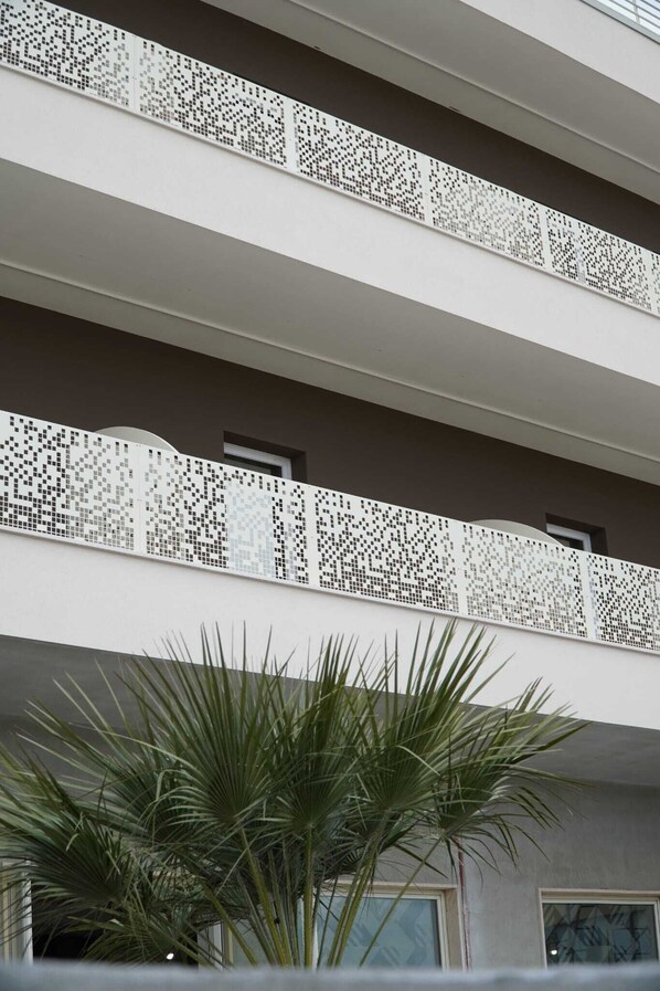 Un edificio de varios pisos con balcones que presentan elaborados diseños de celosía.