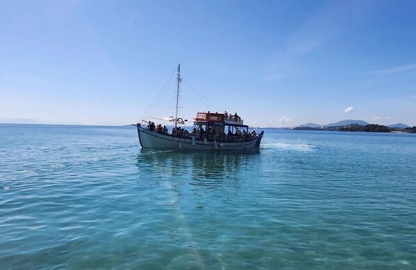 A boat with passengers on a calm sea.