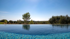 A clear pool with a view of trees and hills in the background. - Villa Ioanna Mentoros (Kefalonia)