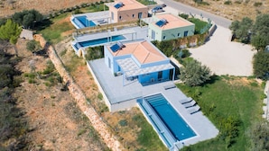 A modern villa with a swimming pool, a covered patio, and a landscaped garden. - Villa Ioanna Mentoros (Kefalonia)