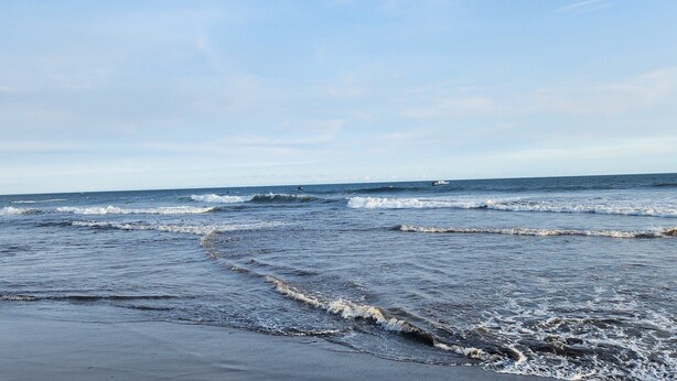 A beach with waves approaching the shore.