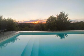 A swimming pool with a clear view of the sunset and surrounding trees. - Le Four à pain, golden triangle Dordogne valley, views garden park swimming pool (saint cybranet)