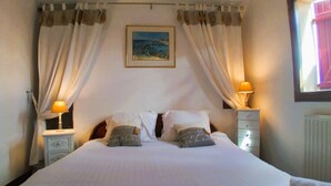 A bedroom with a bed, two bedside tables, a nightstand, a lamp, and a painting on the wall. - Le Four à pain, golden triangle Dordogne valley, views garden park swimming pool (saint cybranet)