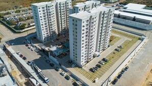 A high-rise residential building with multiple floors, parking areas, and a swimming pool. - Mirante Clube - Praia do Futuro (Fortaleza)