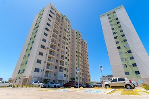 A high-rise building with multiple floors, balconies, and air conditioning units.