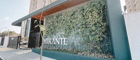 Egy épület, amelynek zöldbe borult, növényekkel borított falával és nagyméretű betűkkel kiírt „MIRANTE” felirata van.