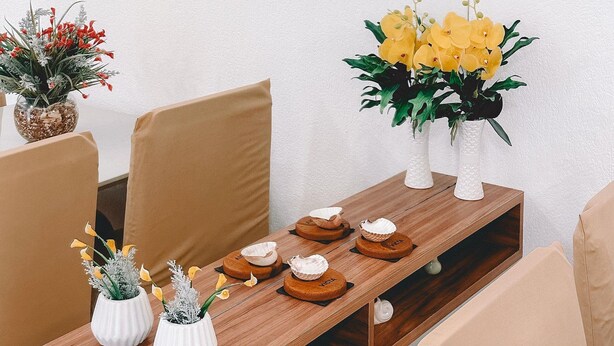 Een eethoek met een houten tafel, stoelen en wanddecoratie.