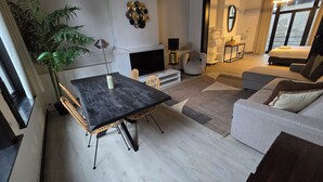 Una sala de estar moderna con comedor, chimenea y un ventanal grande.
