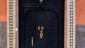 A black door with the number 60, a decorative handle, and a small window above it.