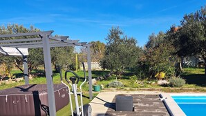 A backyard with a swimming pool, exercise equipment, and a pergola.