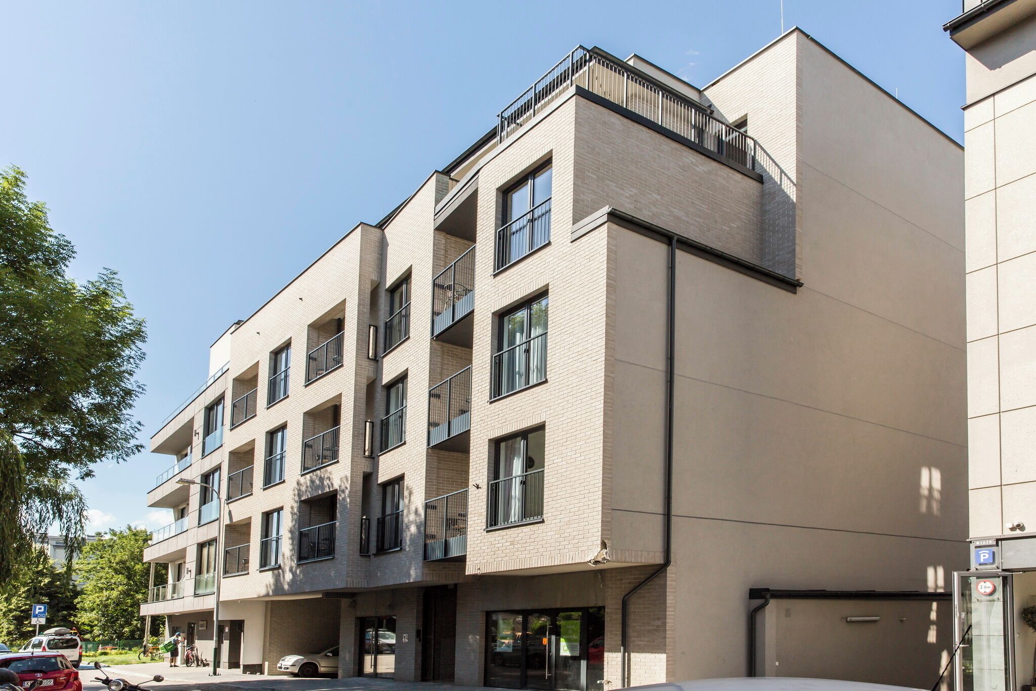 A multi-story building with a modern architectural design, featuring balconies and large windows.