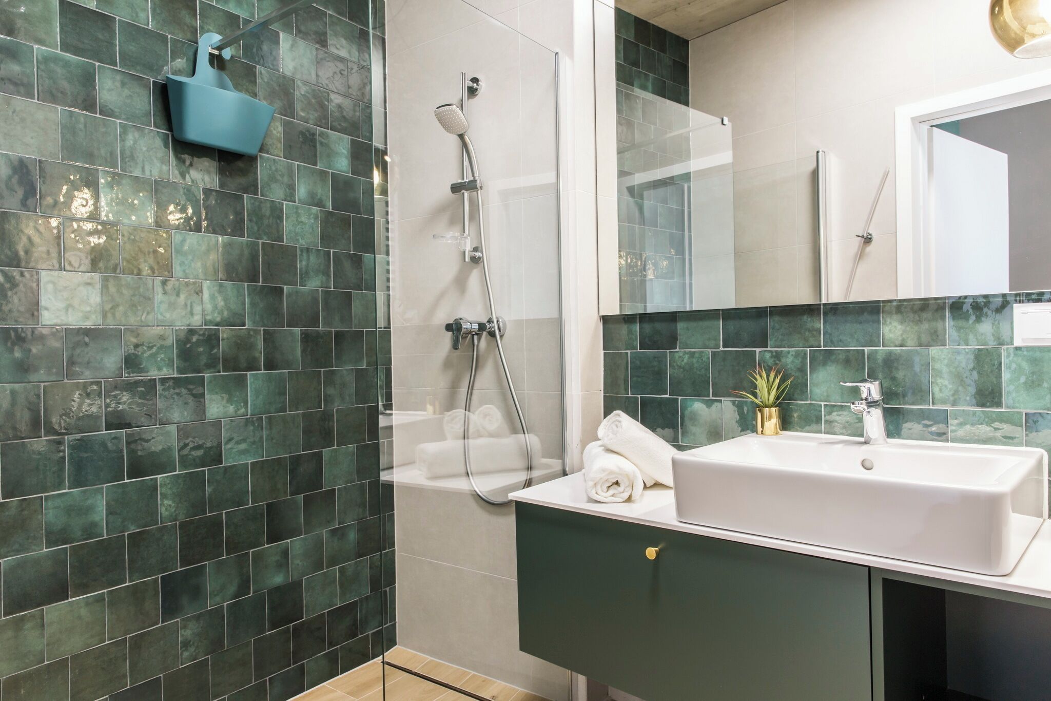 Un baño con ducha, lavabo y espejo.