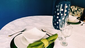 A table set with a white plate, green napkin, and a glass.