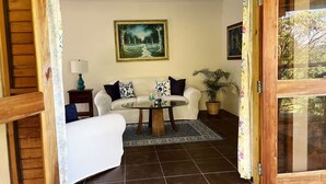 A living room with a sofa, a coffee table, and a painting on the wall.