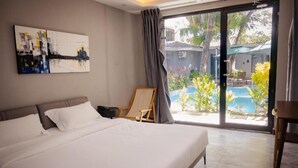 Een moderne slaapkamer met een groot bed, uitzicht op een zwembad en een schilderij aan de muur.