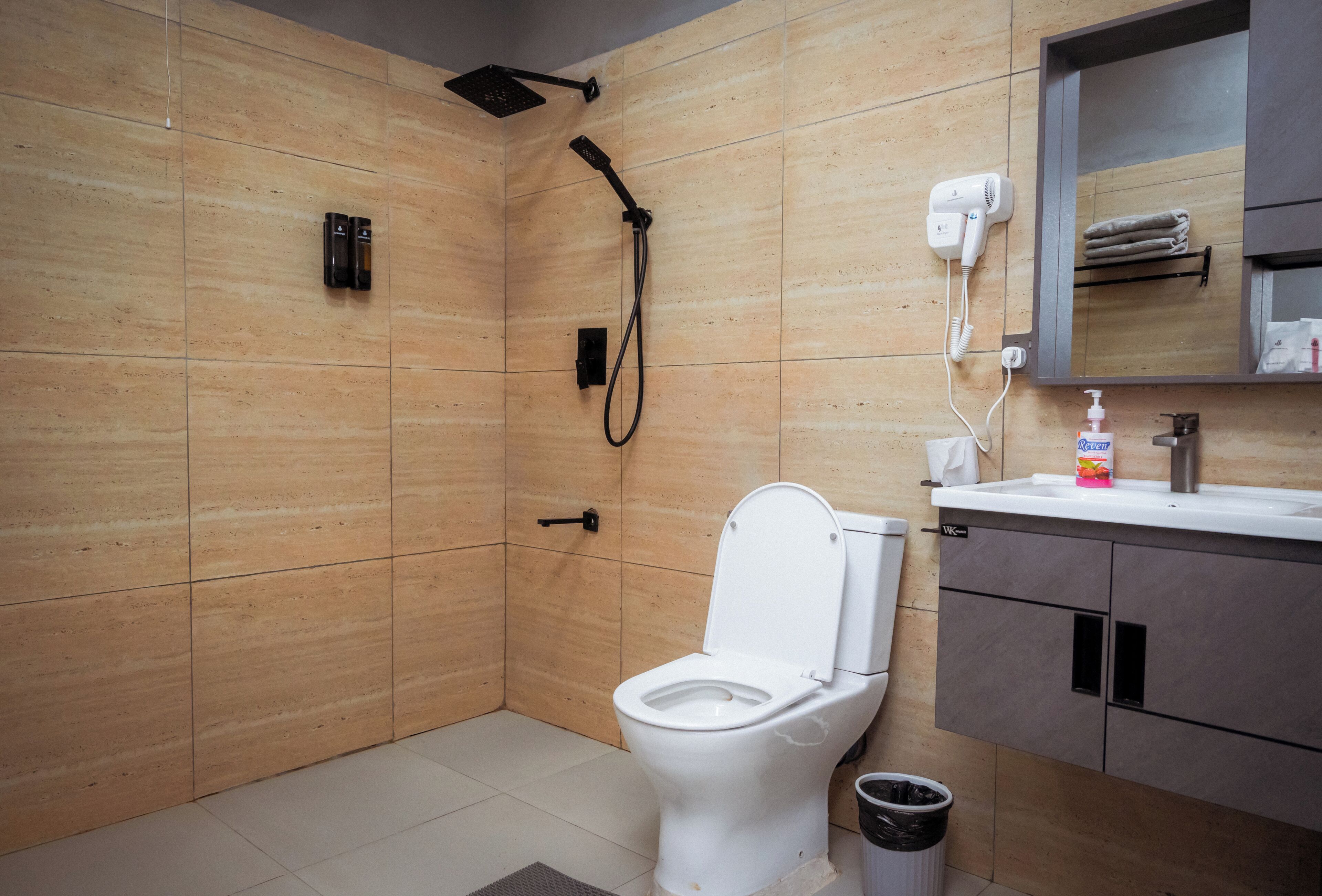 A modern bathroom with a shower, toilet, and sink.