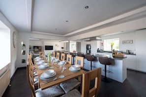 Une cuisine moderne avec un coin repas, des meubles en bois et un îlot central.