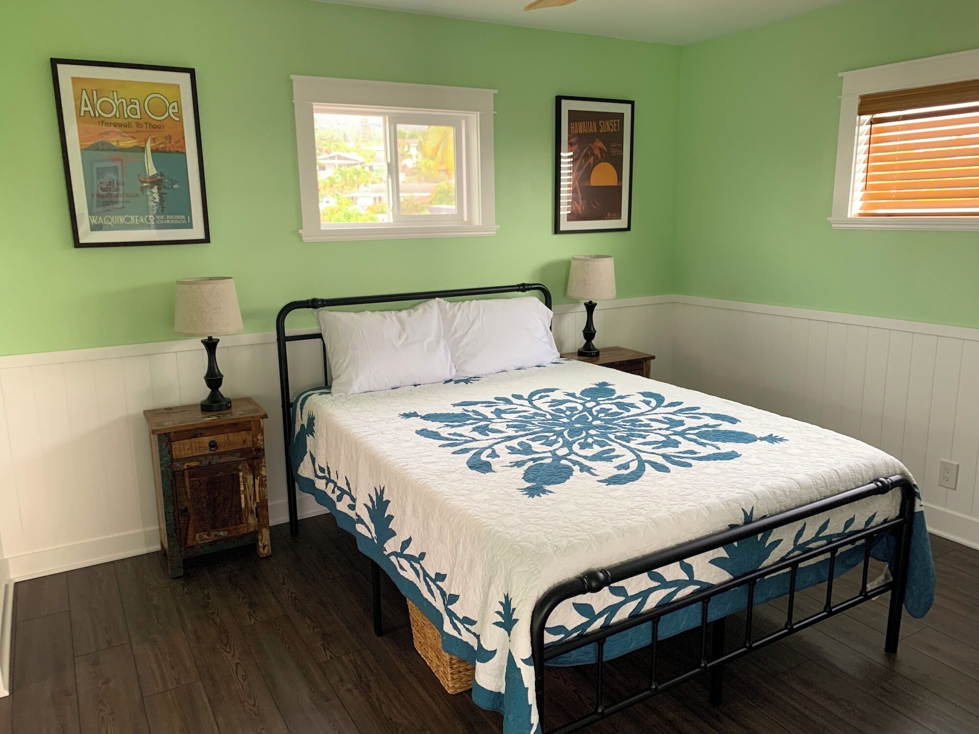A bedroom with a bed, two nightstands, a window, and two wall-mounted lamps.