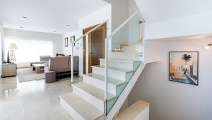 Un salon moderne avec un escalier, un canapé et une table basse.